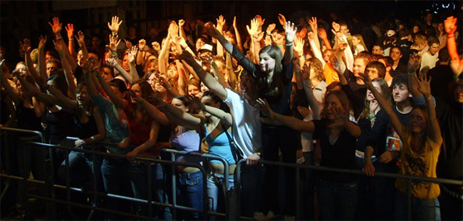 Das Foto zeigt eine große Anzahl Jugendlicher bei einer Abendveranstaltung.