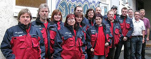 Das Foto zeigt eine Grußße von Menschen in rot-blauen Jacken, des Projekts &quot;Nachtwanderer&quot; vor ihrem insatz
